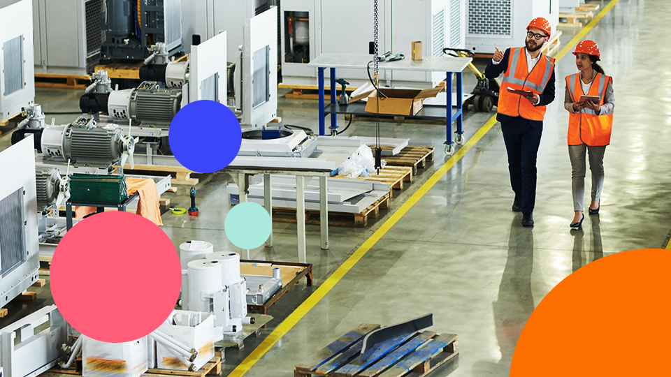 Factory managers carrying out a shop floor walk through a manufacturing production line to observe equipment and operations.