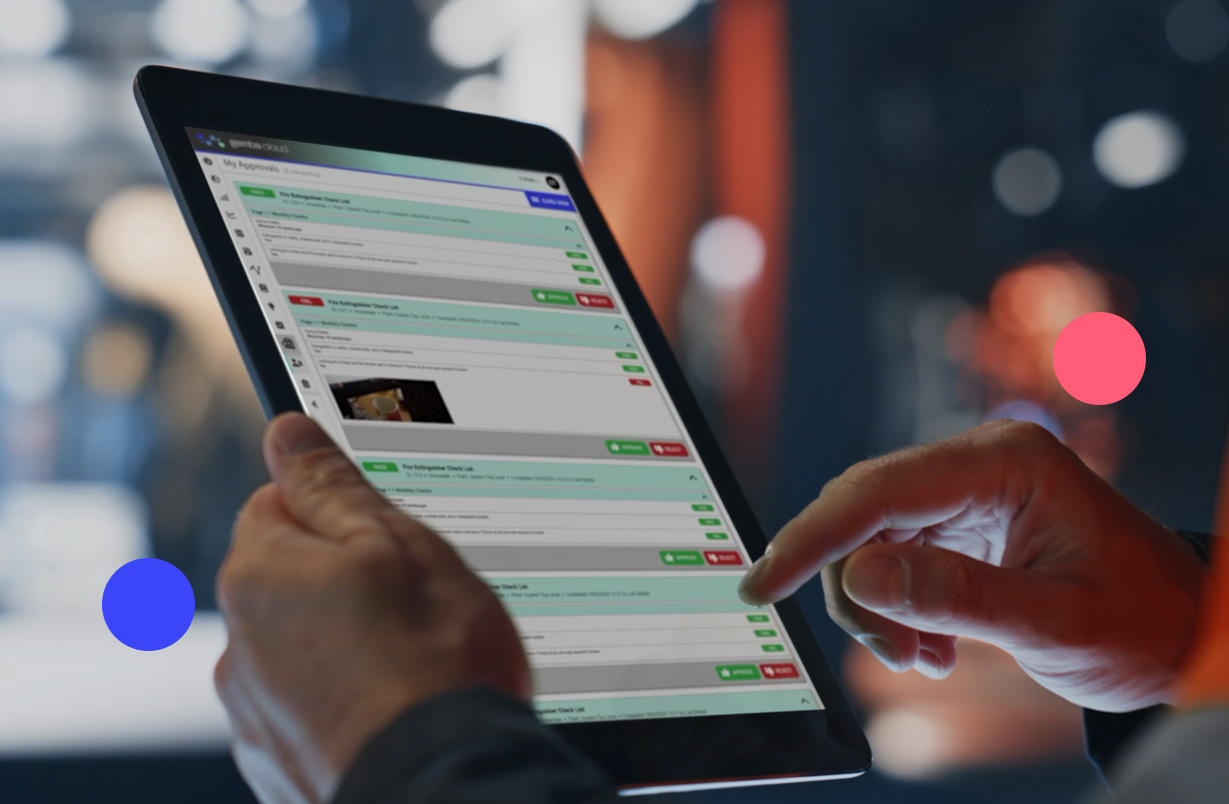 A close-up of a person using a tablet to manage digital approvals and workflows in a manufacturing or business setting.