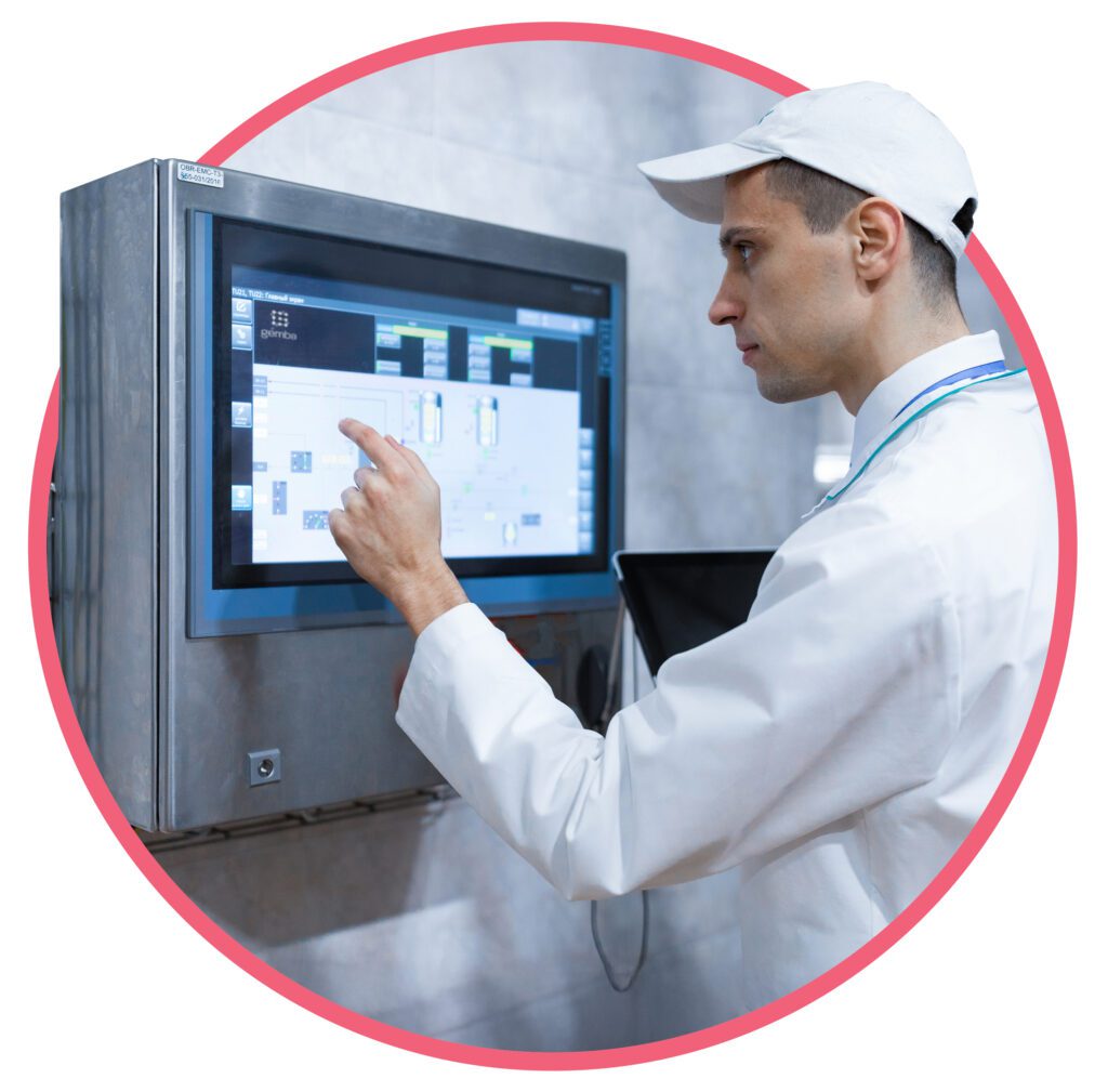 Factory operator using a touchscreen interface to monitor or control production systems.