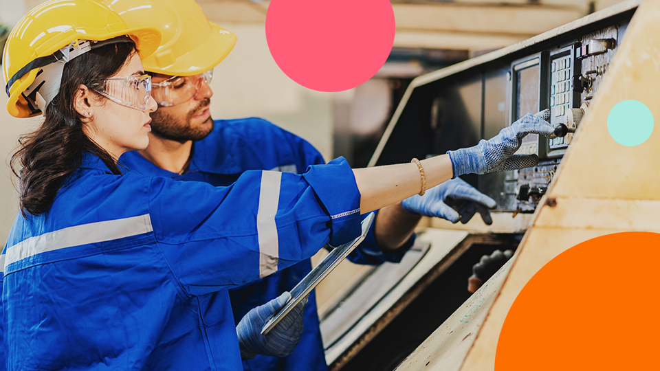 Manufacturing operators reviewing machine controls and production data on the shop floor