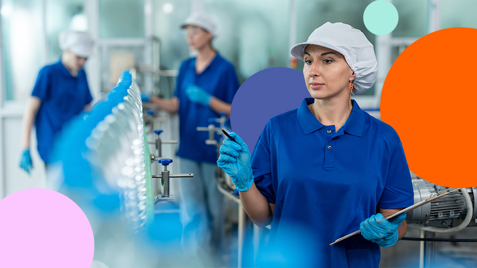 Factory worker in protective clothing inspecting a production line in a food or beverage manufacturing facility.