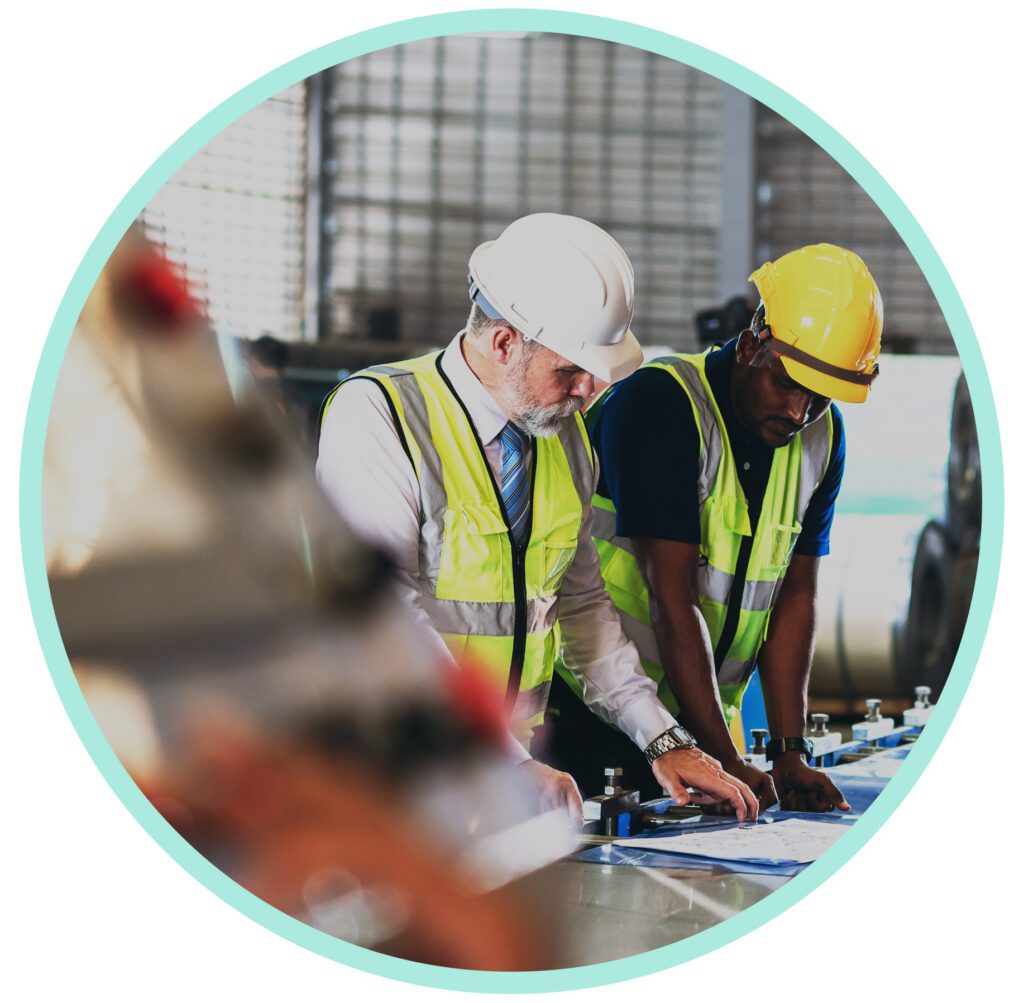 Two manufacturing workers reviewing production documents on the factory floor